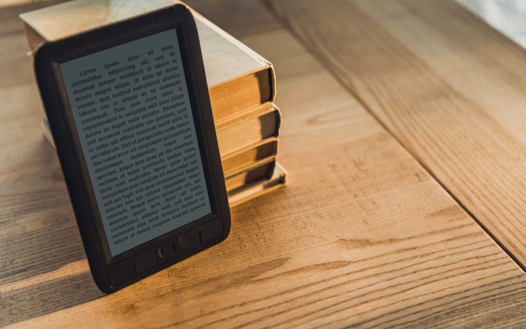 black ebook near paper books on wooden table